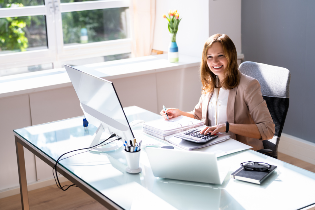 Smiling Bookkeeper computing in front of a computer