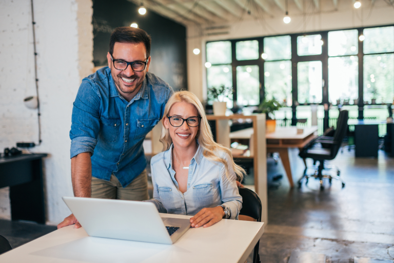 Business owners looking at a computer delegating tasks