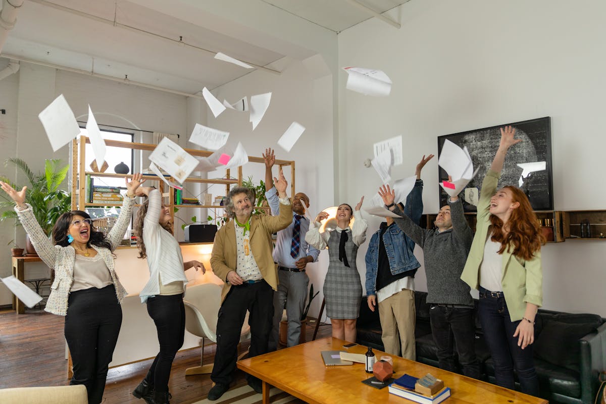 co workers throwing papers in the air