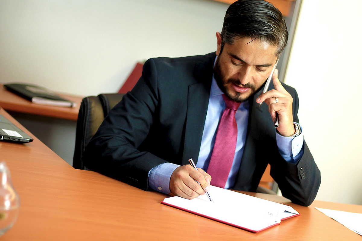 lawyer taking a call and writing notes